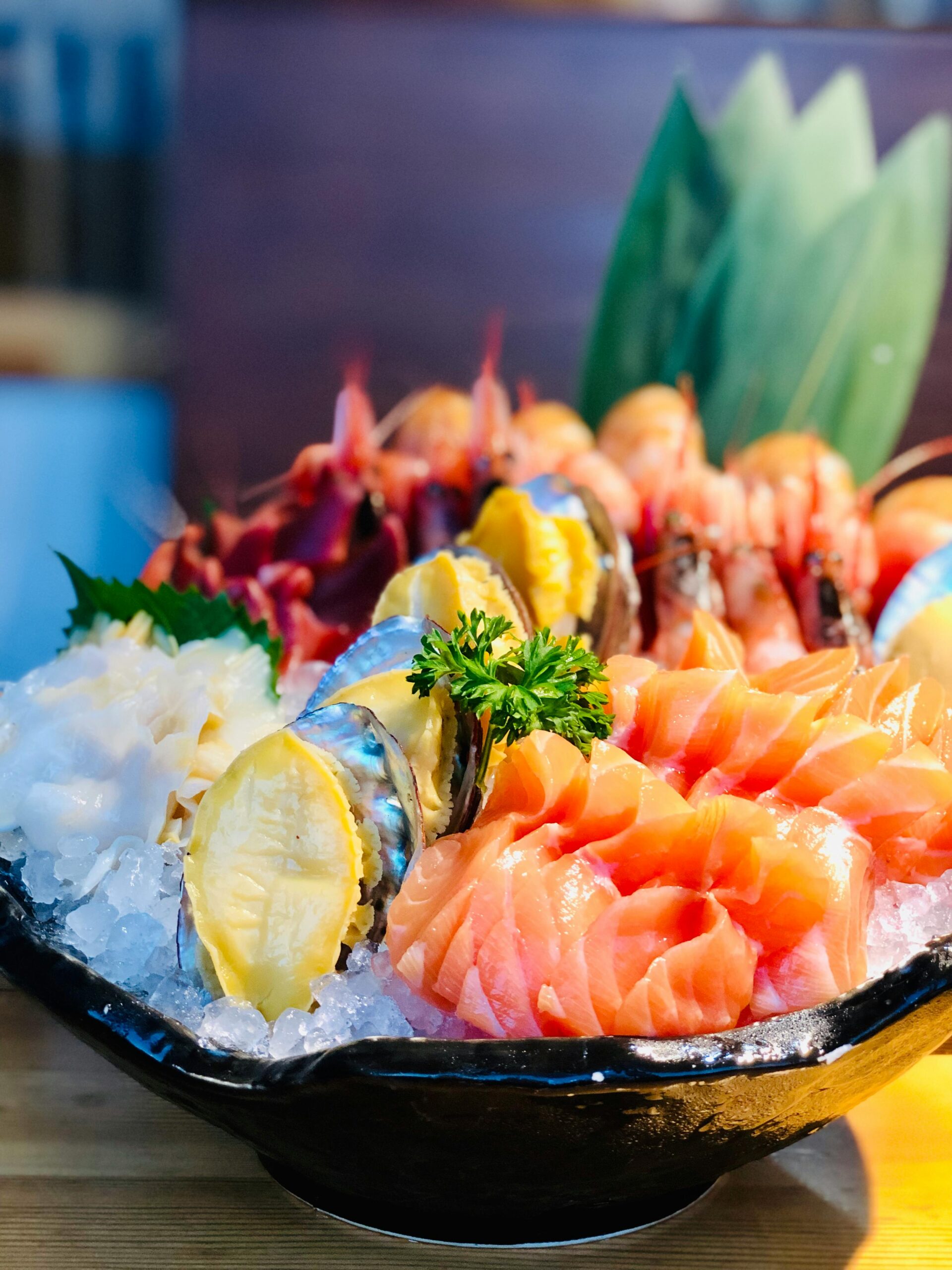 Close-up of a delicious sashimi platter featuring salmon and shrimp, served on ice with garnishes.