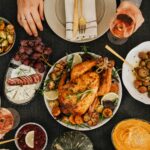 Top-down view of a delicious roast chicken dinner surrounded by sides on a festive table.